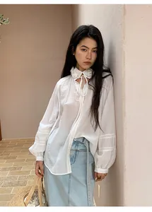 Asian model wearing a white blouse with floral collar and a light blue denim midi skirt