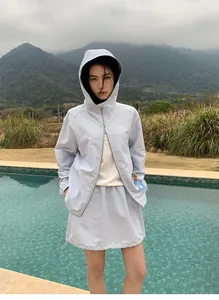 Aziatisch model in een lichtblauwe sportieve outdoor rok met trekkoord bij een zwembad