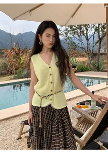 Women's lime green knitted mesh vest with buttons in a resort outdoor setting.