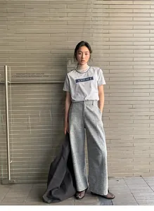 Full-length view of a woman wearing a grey casual sweatshirt and wide-leg trousers set