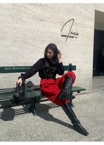 Jean large en denim brossé rouge chic avec de hautes bottes élégantes en cuir noir