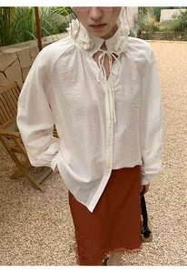 Detalle del elegante borde de encaje floral en una falda marrón rojiza de mujer