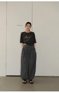 A full-length view of a model wearing retro black and white checkered balloon trousers.