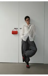 Model wearing vintage checkered loose casual trousers with cuffed ankles in indoor setting