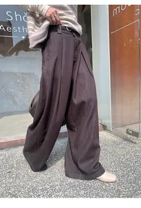 Vue détaillée d'un pantalon en denim marron brossé à jambe large avec ceinture.