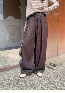 Vue détaillée d'un pantalon large marron foncé à taille haute avec ceinture assortie et texture