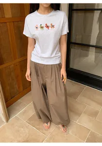 Woman wearing vintage brown checkered wide-leg pants with a grey graphic t-shirt.