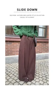 Detail shot of women's autumn brown wide-leg trousers in a casual street setting.