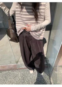 Gros plan d'un jean marron à jambes larges montrant la texture et la coupe sur le modèle.