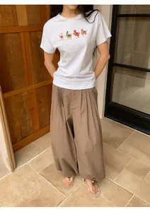Asian woman wearing vintage brown plaid wide-leg pants with a graphic grey T-shirt detail