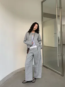 Stylish women's grey two-piece casual set featuring a short jacket and wide-leg pants.