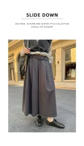 Detailweergave van een wijde broek met hoge taille en riem in een stedelijke straat