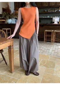 Detailed shot of vintage gingham loose casual pants paired with an orange knit sleeveless top