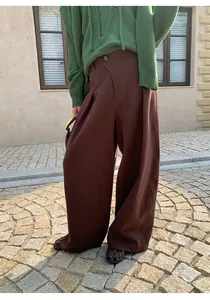Detailed view of elegant women's dark brown high-waisted wide-leg trousers for autumn