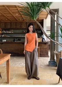 Full view of Asian model wearing retro checkered loose leisure trousers in a rustic café
