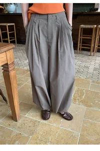 Close-up of retro brown plaid loose balloon trousers with a pleated waist design