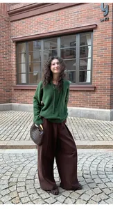 Fashionable women's casual brown wide-leg trousers styled in an outdoor street setting