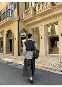 Achteraanzicht van een vrouw in een antracietgrijze wijde broek in een stadsstraat