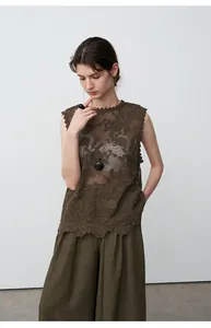 Model wearing dark olive green tencel linen wide-leg pants and lace vest detail view