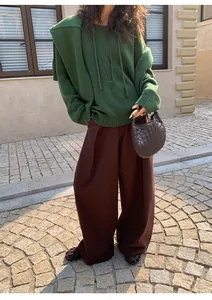 Full-length view of dark brown wide-leg casual trousers on a model outdoors