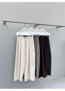 Four colors of wide-leg denim trousers hanging on a minimalist clothing rack