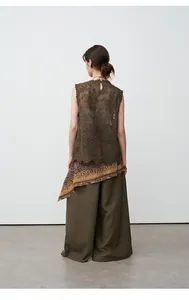 Detail view of olive green wide-leg tencel linen trousers with matching lace top.