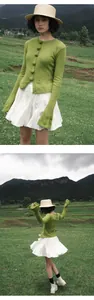 Modelo con minifalda plisada blanca con cintura elástica posando en un campo de montaña