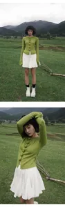 Modelo lleva una falda corta plisada blanca con cintura elástica en un campo al aire libre.