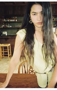 Asian model wearing a light yellow knit vest with mesh stitching in a vintage interior setting