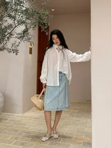 Elegant casual light blue straight denim midi skirt for women in a resort setting