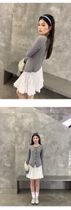 Vista detallada de una falda corta plisada blanca con cintura elástica en una modelo asiática