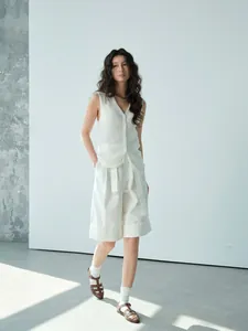 Elegant white paper nano silk mesh patchwork knit vest for women on minimalist studio set.
