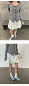 Elegante minifalda plisada blanca con cárdigan gris y zapatillas de deporte azules