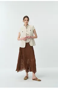 Model wearing a pleated asymmetrical brown skirt with an off-white multi-pocket vest