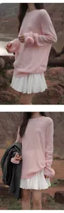 Detalle de la minifalda plisada blanca combinada con un jersey de punto rosa