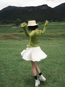 Falda corta plisada blanca con cintura elástica para mujer en un entorno natural de campo