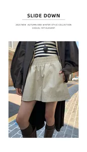 Detailweergave van stijlvolle beige glanzende korte broek van kunstleer met wijde pijpen