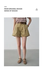 Close-up of stylish high-waisted pleated khaki shorts for women with rolled hem.