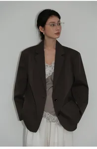 Modella che indossa un blazer oversize marrone scuro per un look autunnale chic da ufficio.