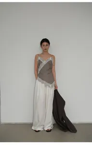 Vista completa di un outfit minimalista con canotta in pizzo grigio e blazer marrone casual.