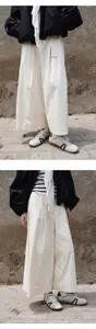 Détail de style jupe-culotte crème pour femme avec baskets rétro en extérieur