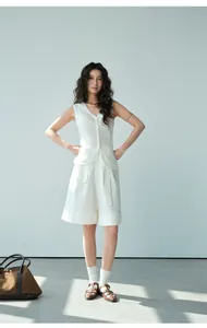 Modelo luce un conjunto de chaleco de punto blanco y pantalones cortos de pernera ancha
