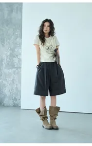 Foto de modelo con pantalones cortos tipo línea A gris oscuro con dobladillo vuelto.