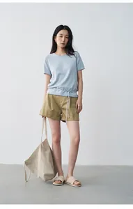Full body model view of women's khaki pleated rolled-up casual shorts with a blue tee