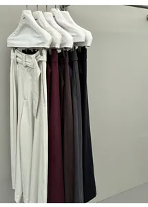 Assortiment effen wijde broeken aan hangers met details van de hoogwaardige gedrapeerde stof