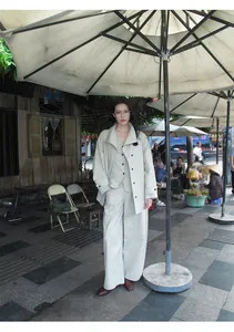 Asian model wearing minimalist beige cotton-nylon blend wide-leg trousers in street setting