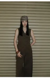 Detailed look of minimalist brown high-waisted wide-leg trousers on an Asian model.
