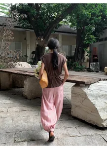 Back view of pink Lyocell Tencel lantern wide-leg trousers in a garden setting