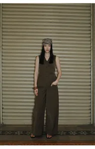 Full-length street style view of dark olive wide-leg trousers and a tailored vest set.