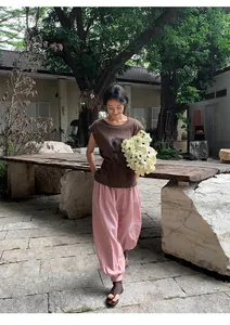 Model wearing pink Lyocell Tencel lantern wide-leg pants in a natural garden setting